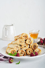 Pancakes. Stack of crepes or thin pancakes with berries, with raspberries and honey for breakfast. Homemade breakfast. Copy space. Selective focus.