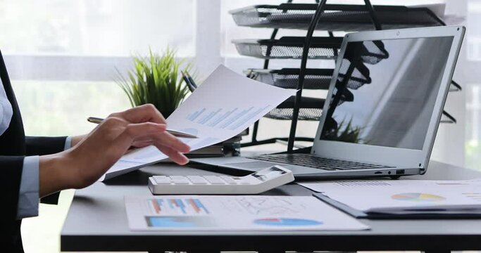 Businesswoman working at office with documents on his desk, doing planning analyzing the financial report, business plan investment, finance analysis concept	