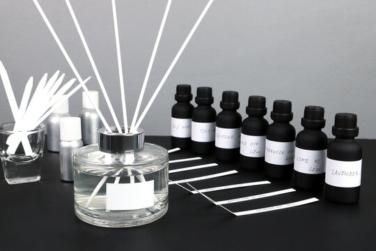 aroma reed diffuser bottle is on black table with essential oil ,frangrance oil bottle and blotter testing paperfor testing smell during blending process for choosing nice scent for reed diffuser