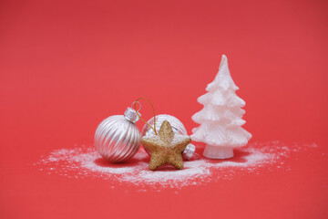 Silver Christmas balls, gold star and white Christmas tree on red background with copy space. Concept winter card.