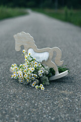 A bouquet of wildflowers and a decoration horse on the road - 540746103