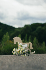 A bouquet of wildflowers and a decoration horse on the road - 540746118
