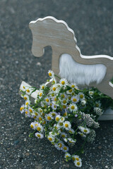 A bouquet of wildflowers and a decoration horse on the road - 540746186