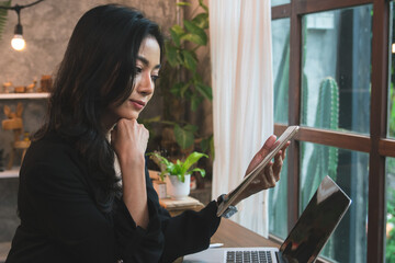 Lifestyle of female entrepreneur sitting at a modern coffee shop, businesswoman using laptop to...