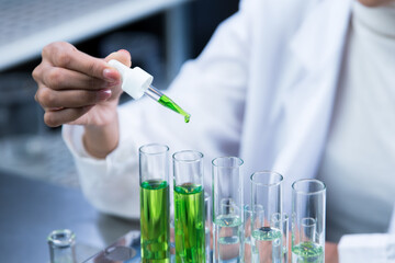 Close-up of Scientists are dripping organic plant extracts into test tubes and plates in the laboratory, Researchers testing plant-based drugs.