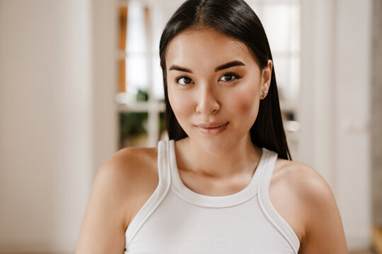 Young Beautiful Calm Asian Woman In White Sleeveless T-shirt