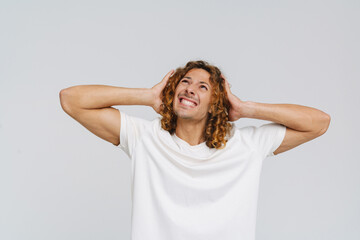 Ginger european man grimacing while holding his head