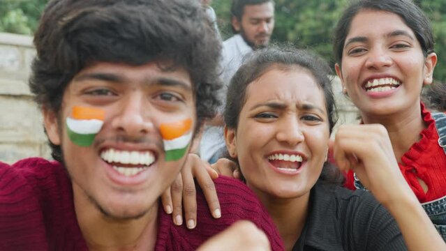 focus on girls, cheerful excited happy friends with painted indian flag on face shouting during watching sports at stadium after win - concept of friendship, celebrating victory and fans.