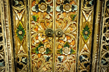 Bali style green wooden carved door in the traditional house of Ubud, Bali, Indonesia