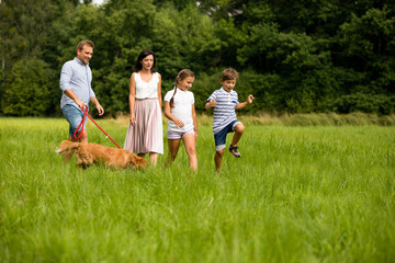 Young family walking together with dog spending happy time