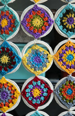 Crocheted flowers hanging on wall texture background