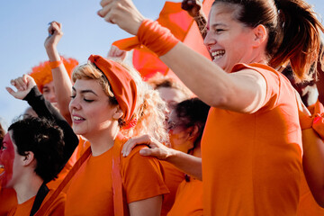 Orange sport football fans celebrating with crowd cheering team on stadium tribune - Soccer...