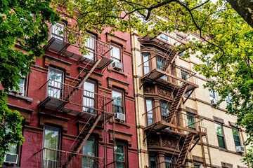Façade of picturesque houses in Brooklyn Heights with external fire escape stairs, New York City,...