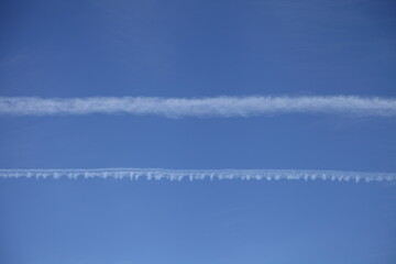 Clear blue sky with double vapor exhaust from aircraft background texture