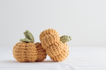 Cute crochet knitted yellow pumpkins on white background