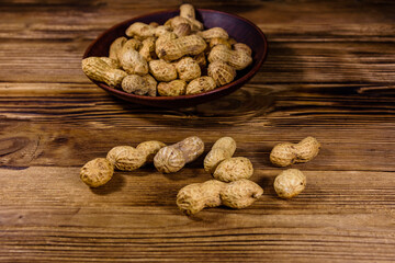Heap of unpeeled peanuts on a wooden table