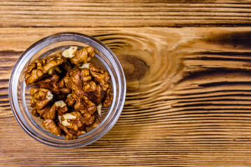 Cores of walnut in glass bowl on a wooden table. Top view