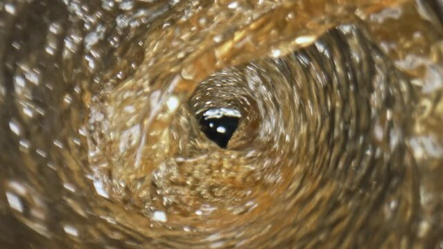 Alcoholic liquid filling glass closeup. Cold golden ale foaming pouring goblet
