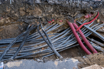 Connecting fiber optic internet connection network cables. Upgrade infrastructure in the city. Construction site with a lot of high speed communication cables buried underground in the street.