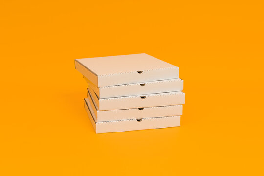 pizza boxes stacked on yellow background