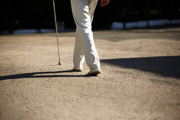 A blind man with a stick walks down the street. The concept of disability.