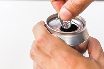 Person opening an open aluminum can on white background.