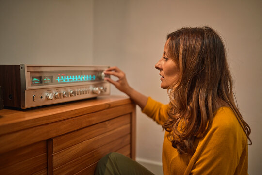 Blond Woman Adjusting Knob On Vintage Receiver