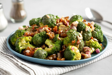 Homemade Broccoli Bacon Salad on a Plate on a gray background, side view. Close-up.