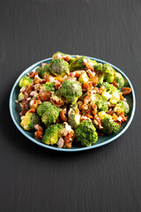 Homemade Broccoli Bacon Salad on a Plate on a black background, side view.