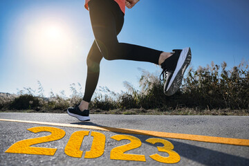 A woman running on a track with 2023 on it