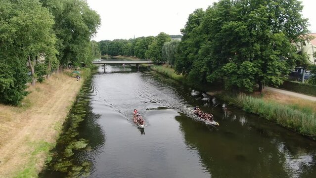 Drachenboot Mannschaft f&auml;hrt Rennen auf einem Fluss (Werre in Herford) Teamsport Kanu Rennsport Wassersport Luftaufnahme