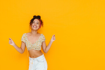 Curly brunette woman in earphones dancing and listening music