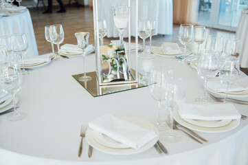 Luxurious restaurant. Luxurious interior, white tables, serving dishes and glasses for guests
