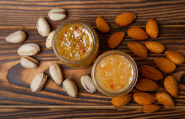 Honey in a glass jar. Nutty honey on a brown texture table. Remedy for colds and respiratory diseases. Organic product of a vegetarian diet. copy space.