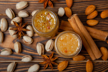Honey in a glass jar. Nutty honey on a brown texture table. Remedy for colds and respiratory diseases. Organic product of a vegetarian diet. copy space.
