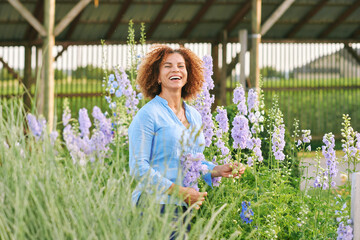 Outdoor portrait of beautiful 50 year old woman enjoying nice day in flower park or garden, happy and healthy lifestyle - 540778190