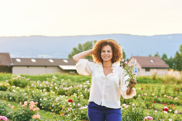 Countryside lifestyle, outdoor portrait of beautiful middle age 50 - 55 year old woman enjoying nice day in flower farm garden