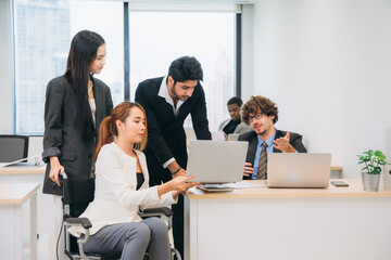 Businesswoman holding a meeting, conference, and conversation with his team while seated in a wheelchair at the workplace.