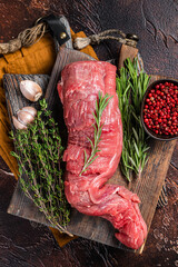 Uncooked beef veal tenderloin, raw meat for fillet mignon steaks. Dark background. Top view - obrazy, fototapety, plakaty