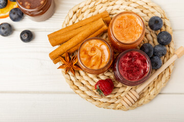 Jar of honey. Fruit honey with raspberries, blueberries, almonds and pistachios. Jams for health and beauty. Honey cream. Organic product of a vegetarian diet. Copy space.Copy space.