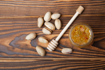 Honey in a glass jar. Nutty honey on a brown texture table. Remedy for colds and respiratory diseases. Organic product of a vegetarian diet. copy space.