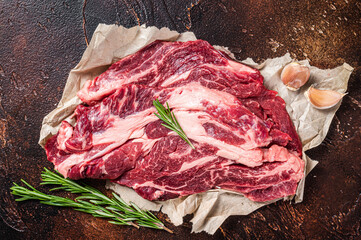 Unccoked marble black angus meat Steak on kitchen table, beef chuck roll steak. Dark background....