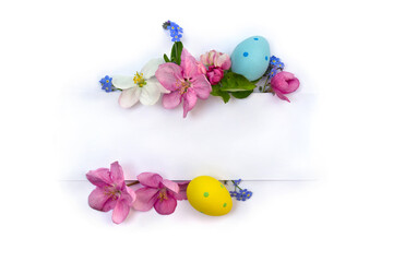 Easter decoration. Pink and white flowers apple tree with Easter eggs and white paper card with space for text on a light background. Top view, flat lay