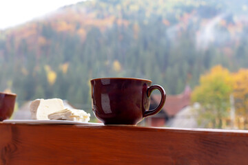 A cup with a hot drink and cheese on the background of the mountain