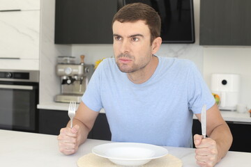 Impatient looking man waiting for dinner to be served 