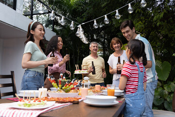 Multi-ethnic family having fun and enjoying outdoor party in the garden at home, Celebrate party of long weekend concept
