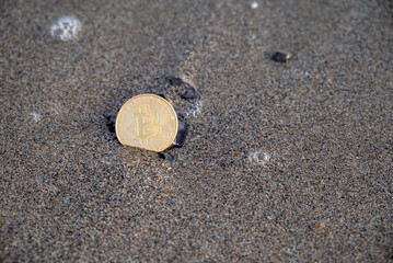 Fototapeta na wymiar Bitcoin Coin Lies In Sand On Beach On Sunset Moraitika, Corfu, Greece. The Concept Of Payment For Nature And Unlimited Possibilities. Copy Space