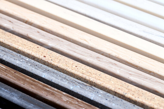 Porcelain multicolored stoneware square long samples as kitchen countertop examples of future kitchen fasade exterior. Samples slabs of natural granite marble quartz for stone countertops close up.
