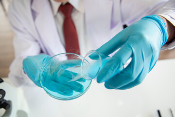 Biologist sits at table with test tubes. Work in quality inspection laboratory on laboratory