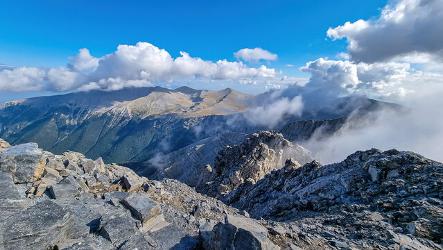 Panoramic view from cloud covered mountain summit of Mytikas Mount Olympus, Mt Olympus National Park, Macedonia, Greece, Europe. Home of the Ancient Greek gods. Hiking trail from Skala and Stefani